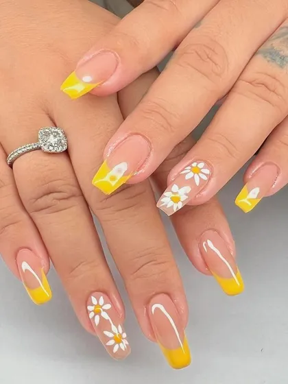 A bright and sunny design with a yellow French tip on long, square nails, accented with hand-painted daisies.