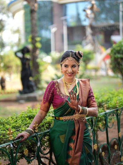 A classic Brahmin wedding look. The nine-yard Madisar saree is draped perfectly, and the makeup is kept traditional and elegant, complete with a classic hair bun and jewelry.