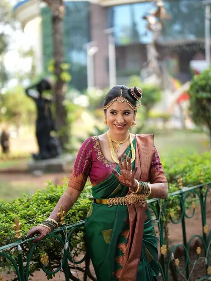 A classic Brahmin wedding look. The nine-yard Madisar saree is draped perfectly, and the makeup is kept traditional and elegant, complete with a classic hair bun and jewelry.