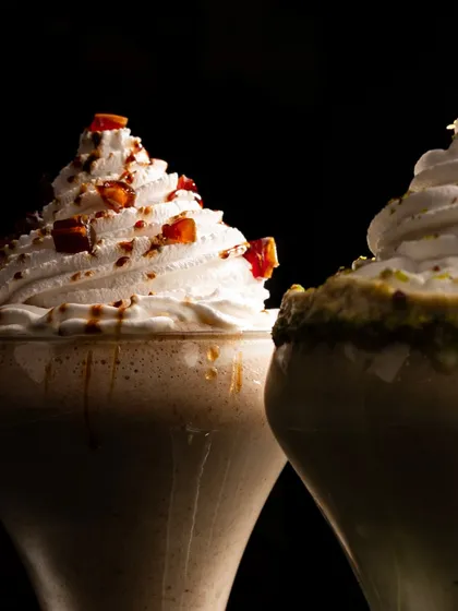 Decadent milkshakes from Hurrem's, with dramatic lighting that catches the whipped cream and caramel drips. This moody style makes the dessert feel extra indulgent.