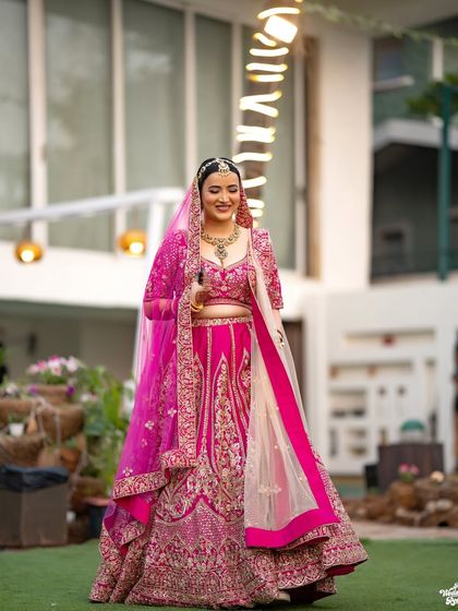 The bride in her magnificent pink lehenga, a full-length shot capturing the grandeur of her wedding day look.