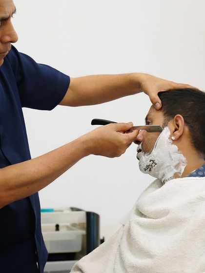 A close-up of the straight-razor shave in action. My focus is on precision and client comfort, ensuring every stroke contributes to a perfectly smooth result.