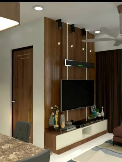 This view from a Lodha Amara project shows the living area with a leatherette sofa and a fluted wood TV panel. The design balances warm wood tones with modern furniture for a comfortable yet stylish home.