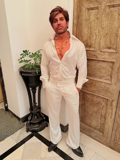 Our client Mr. Birla looking stylish in a custom-made all-white outfit, featuring a silk shirt and matching flared trousers for a bold, glamorous look.