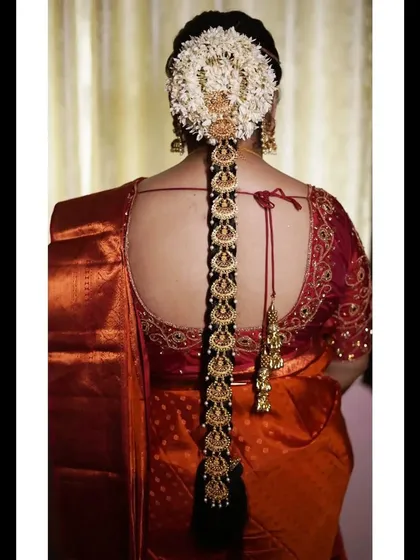 To complete a traditional bridal look, I offer exquisite hair accessories like this lightweight bridal jada. This piece, seen here adorning a classic bridal braid, features beautiful Lakshmi motifs and is designed to add a divine touch without feeling heavy.