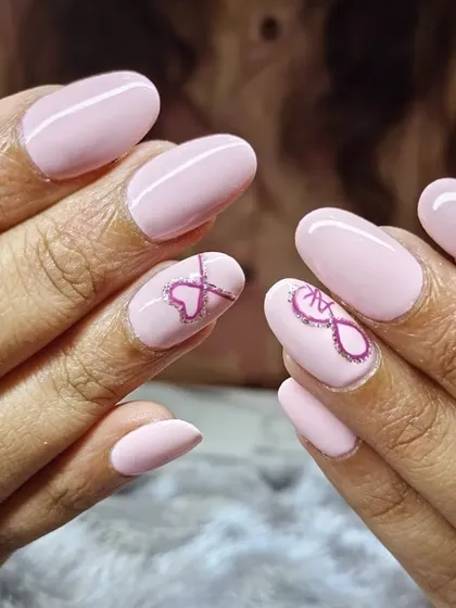 This trendy "pinky punky" look on oval nails features a delicate, hand-drawn infinity heart design. It's a perfect example of custom line work that adds a personal touch to your manicure.