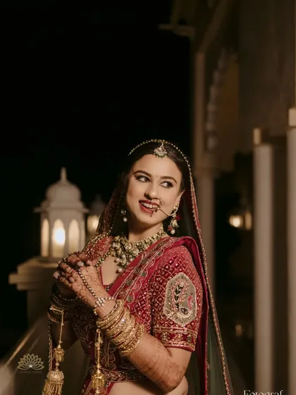 A candid shot of the bride, her smile as bright as her jewelry. Her mehndi-adorned hands add a touch of traditional elegance to the moment.