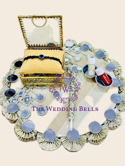 For a modern and chic vibe, this Rakhi tray with mirror work is a perfect choice. It's elegant and reflects the festive spirit beautifully.