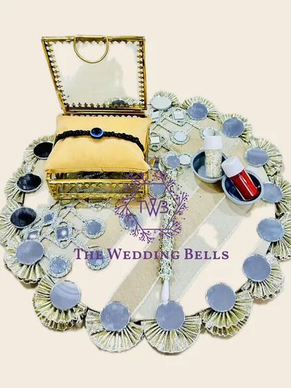 For a modern and chic vibe, this Rakhi tray with mirror work is a perfect choice. It's elegant and reflects the festive spirit beautifully.