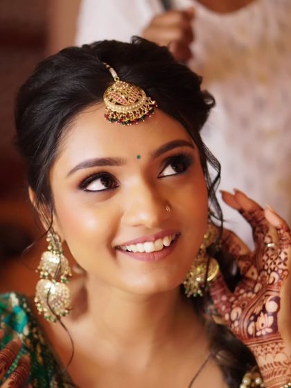A final, beautiful shot from Nony's Mehendi. This image captures the final touches, with her hand framing her face, showing how the makeup, hair, and henna all come together.
