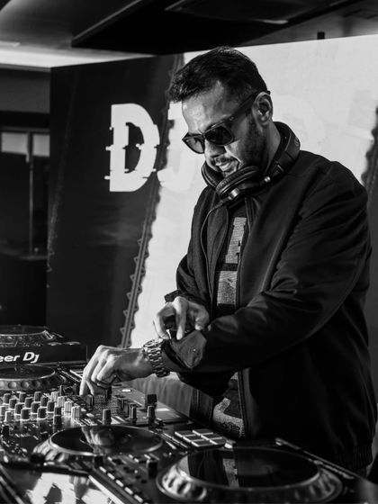A black and white action shot of me adjusting the levels on my Pioneer DJ mixer. Every little adjustment is about perfecting the sound for the audience.
