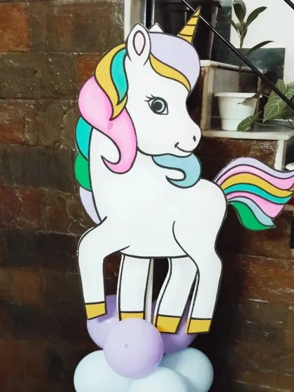A unicorn character cutout placed on a purple and white balloon pillar. These are versatile decorations that can be placed anywhere in the party area.