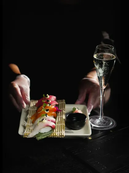 Between the artful press of skilled hands and the ocean's finest ingredients lies the ephemeral culinary poetry of our nigiri platter, served alongside a glass of sparkling wine.