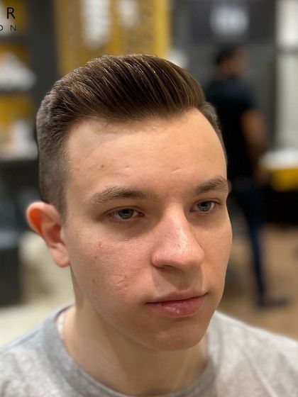 A clean, high-quality shot of a finished classic men's haircut. The focus here is on the sharp lines and smooth styling, showcasing the kind of polished result you can expect at the salon.