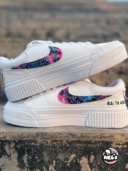 A stacked pair of our galaxy-themed Nikes, showing the matching cosmic swooshes and personalized text on the heels.