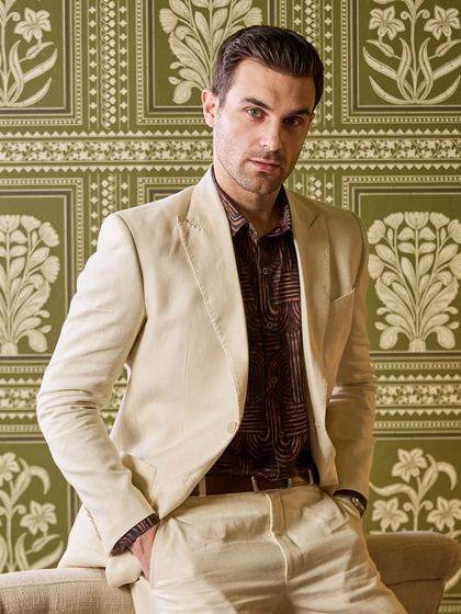 This close-up of the ivory linen suit highlights its clean silhouette and the quality of the fabric. It's a dapper and comfortable choice for looking your best in the heat.