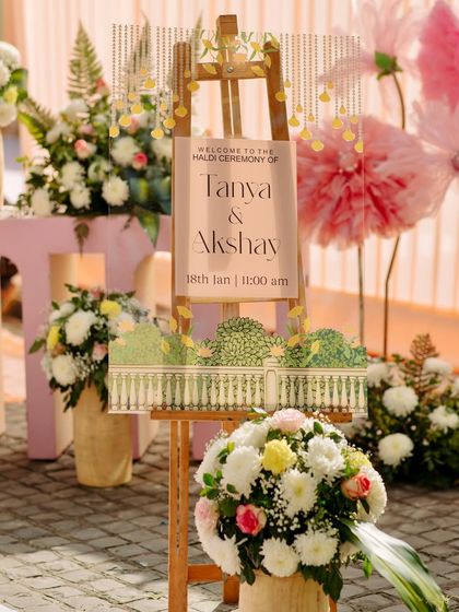 The beautifully designed welcome sign for the Haldi ceremony, featuring custom graphics that match the elegant and sunny theme of the event.