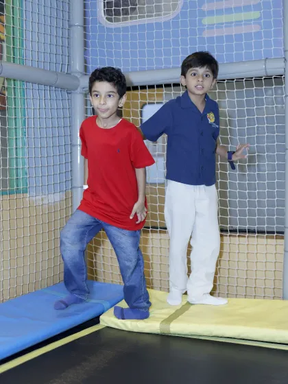 Two friends bounce together in our trampoline park, a great way to burn off some energy.