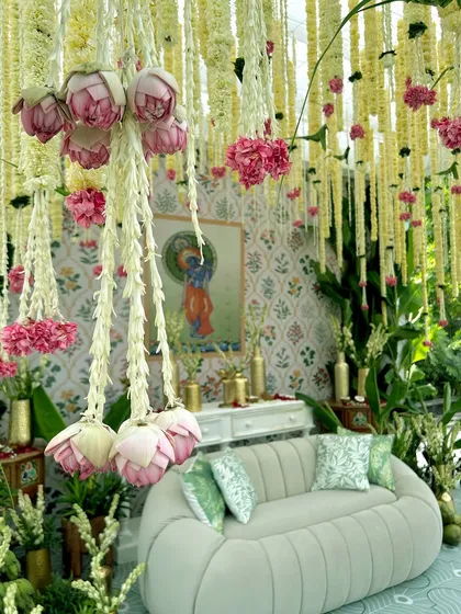 We honor tradition with elegance and artistry. This South Indian themed Haldi setup features a canopy of fresh jasmine and lotus flowers, with a backdrop of Pichwai art, creating a serene and culturally rich ambiance.