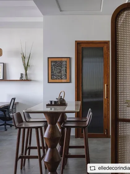 A close-up of the high table in the 'Sepalika' office, showing the beautiful grain of the wood and the unique design of the table legs.
