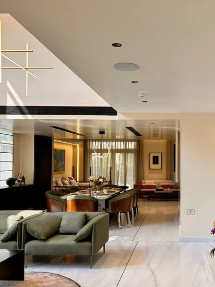 A view from the living area looking towards the dining space in the Palm Springs Villa. The open-plan layout and consistent material palette create a seamless flow between different functional zones.