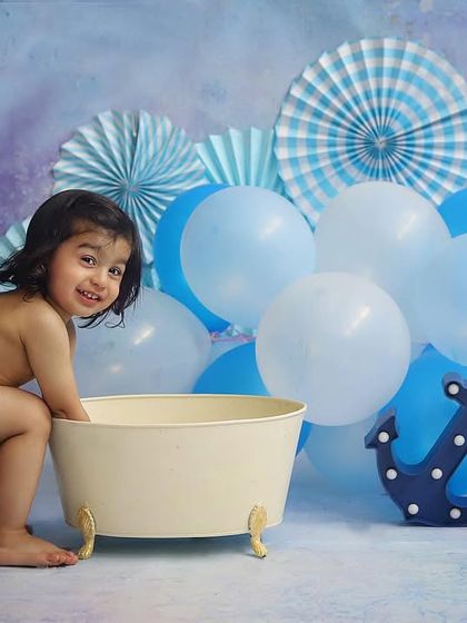 A simple and sweet bathtub session with a blue nautical theme. The anchor prop and blue balloons create a fun, sky-and-sea vibe for this little splasher.