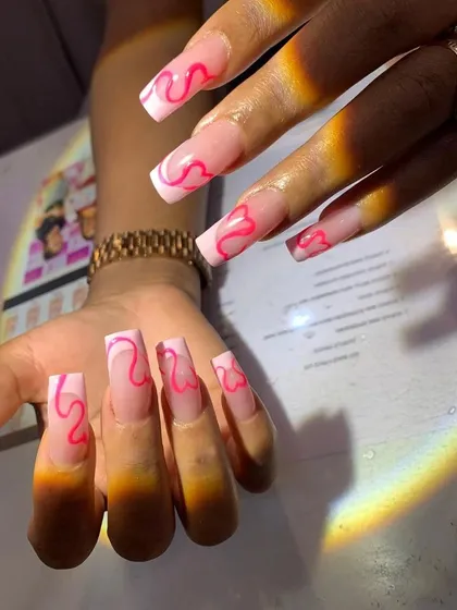 Extra-long, square-shaped clear extensions with a playful pink heart-line design. This look is trendy, fun, and perfect for those who love statement nails.
