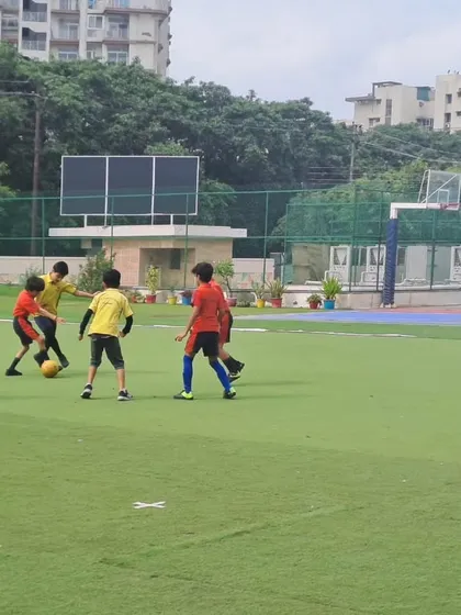 An action shot from the boys' Inter-House Football Tournament, with players from opposing houses vying for the ball. The fast-paced game showcases the students' agility and strategic thinking.
