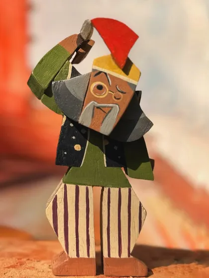 This figurine represents one of the film's vibrant supporting characters. The unique pose, colorful attire, and expressive face are all carved and painted by hand to match the movie's aesthetic.