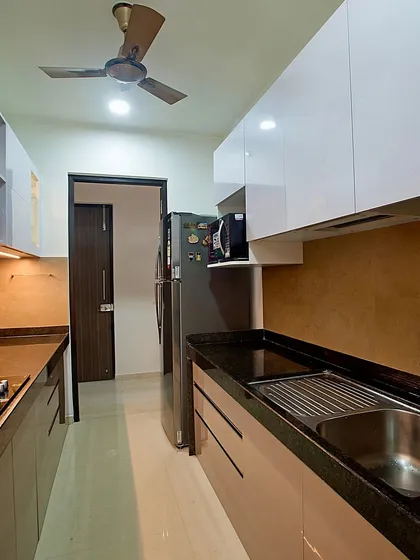 A view of the parallel kitchen, showing the placement of the refrigerator and the seamless cabinet design.