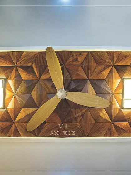 A custom ceiling light fixture integrated into a 3D wood-paneled ceiling. The fan is mounted in the center, creating a design that is both decorative and perfectly functional.