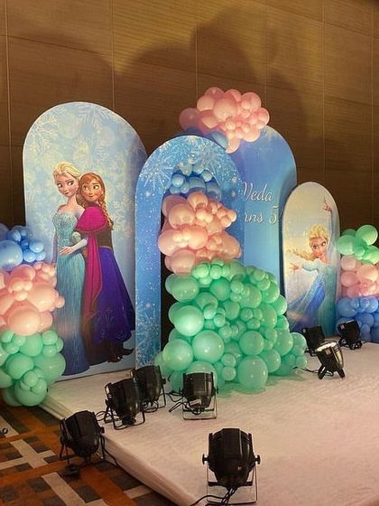 Another angle of the Frozen party stage, showing both Anna and Elsa on the backdrops, surrounded by beautiful balloon clusters.