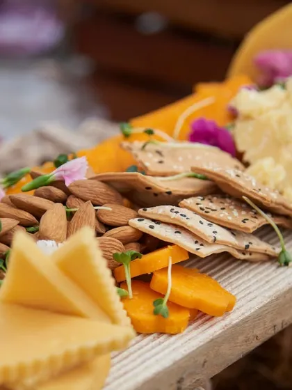 Another angle of a classic cheeseboard, showcasing a variety of hard and soft cheeses alongside fresh almonds and crackers. A perfect start to any celebration.