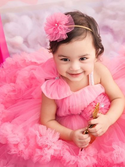 A close-up portrait of our little Barbie girl, looking absolutely precious in her fluffy pink dress during her themed birthday session.