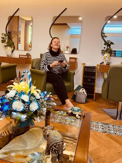 A client relaxing in our salon space, surrounded by fresh flowers and a calm environment.