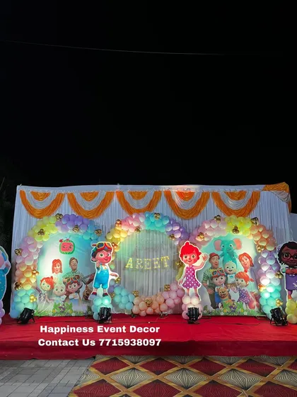 A wide shot of a large Cocomelon stage setup in a hall, showing the scale of the decoration with multiple character props.