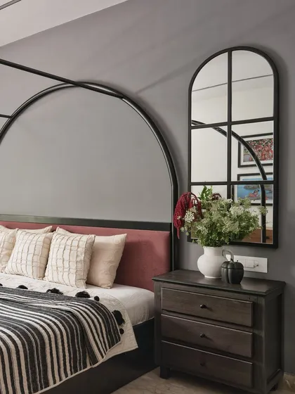 To complement the bed's dramatic arches, I placed arched mirrors on either side above the nightstands. This detail not only echoes the bed's form but also adds depth and reflects light, making the room feel more spacious.