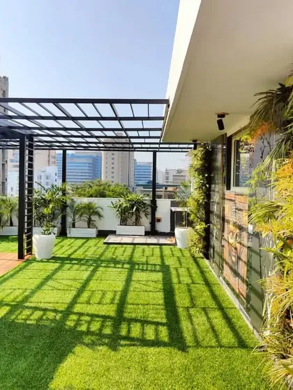 A wide shot of the South City 2 terrace, showcasing the long vertical garden, pergola, and planters that transform the entire length of the space.