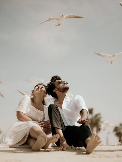 A joyful and spontaneous moment on a Dubai beach, with seagulls taking flight around the happy couple. These are the candid shots that bring a gallery to life.