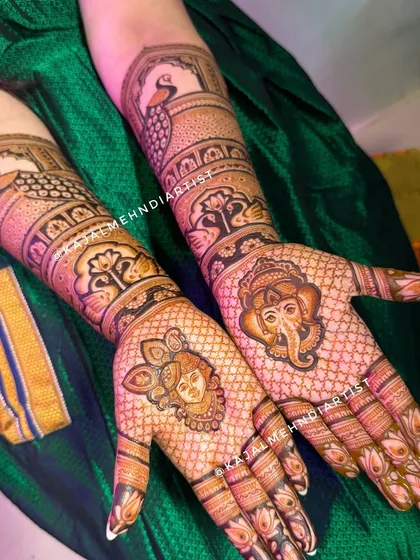 This bridal design is filled with blessings, featuring a Shreenathji portrait on one hand and a Ganpati portrait on the other.