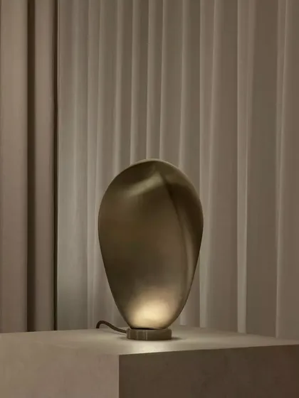 The bronze glass Solace lamp, its surface catching the light to create a subtle shimmer, adds a touch of understated luxury.