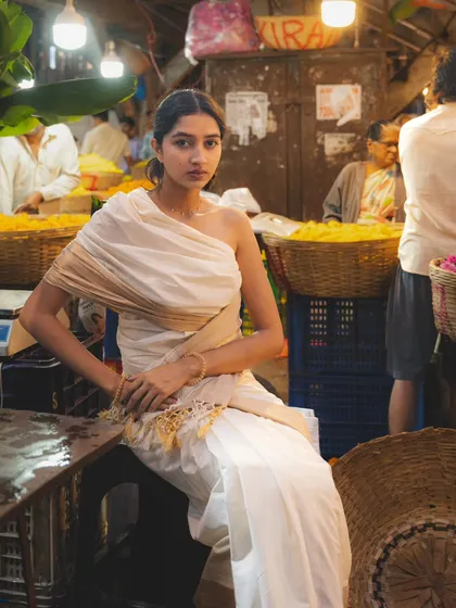 Taking a seat amidst the market activity. This portrait has a candid, documentary feel, capturing the subject as a natural part of the environment.