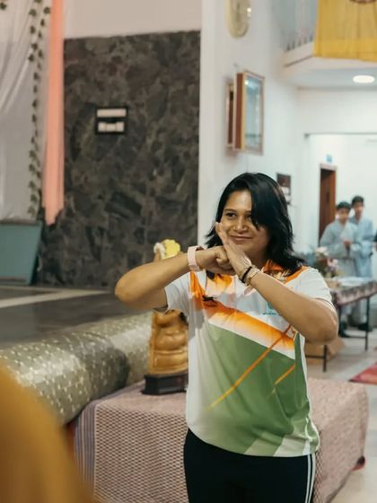 A moment of instruction during a demonstration. The hand gesture is a traditional salute in Chinese martial arts, signifying respect and humility.