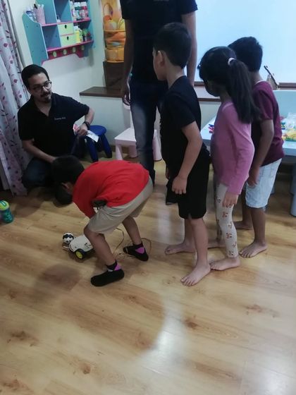 Students gathered around to test a robot they built. Teamwork and peer learning are key components of our teaching philosophy.