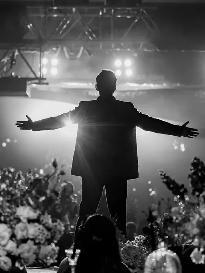 A powerful silhouette of the groom during his solo performance. The backlighting and stage setup were designed to create this iconic, rockstar moment.