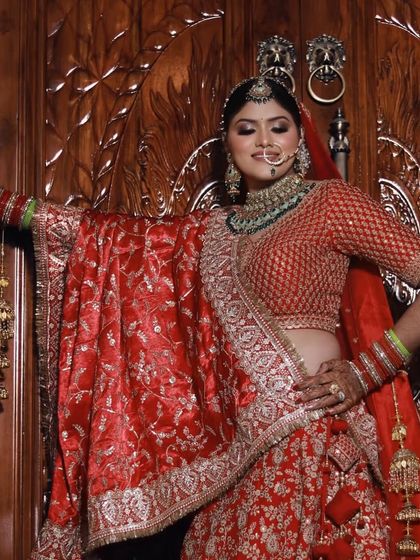 A closer look at this stunning bride against a beautifully carved wooden door. The rich red of her lehenga and the soft glam makeup create a look that is both traditional and modern.