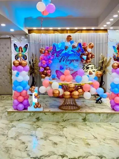 A full view of the butterfly-themed stage, showing how it looks in the context of the party hall. The setup is perfect for cake cutting and photos.