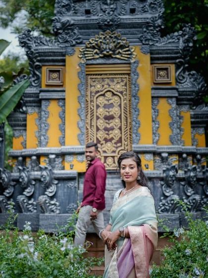 A beautiful shot of a model in a traditional saree against a Balinese-style temple backdrop.