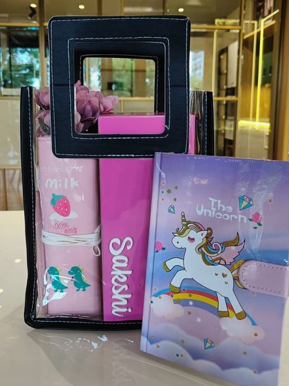 A unicorn-themed hamper for kids. This gift set includes a unicorn diary and a personalized pouch, all packed in a transparent bag.