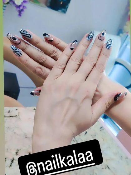 A modern and abstract design with a sheer base and swirls of black and silver glitter.